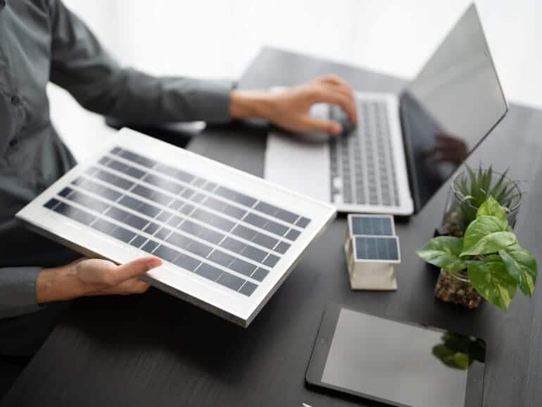 3-bespoke-design-770x433 Person working with solar panel and laptop for solar energy solutions.