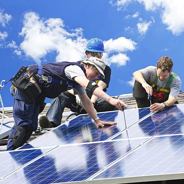 Team installing solar panels on a sunny day for renewable energy.